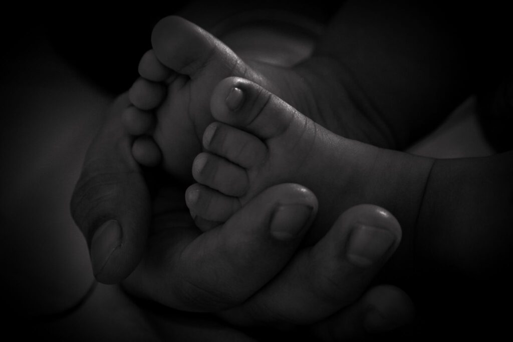 Babyvoetjes in de handen van een moeder